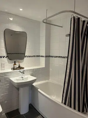 a white bathroom with a sink and a bath tub at Luxury 2 bedroom town apartment in Aberystwyth