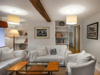 a living room with two white couches and a table at Sheldon Cottage in Bishops Castle