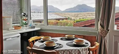 a table with four coffee cups on it in front of a window at Hamishs log cabin in Trawsfynydd