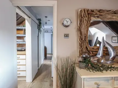 a hallway with a mirror and a clock on the wall at Top Cottage Barmouth in Barmouth