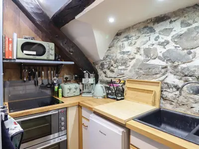 a small kitchen with a stone wall at Top Cottage Barmouth in Barmouth