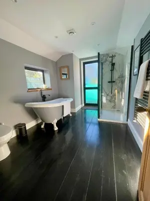 a bathroom with a bath tub and a toilet at Stunning fully refurbished house in New Quay