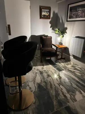 a living room with a barber chair and a table at Stunning fully refurbished house in New Quay