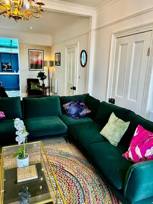 a green couch in a living room with a table at Stunning fully refurbished house in New Quay