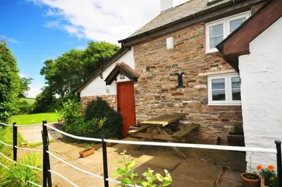 a brick house with a picnic table in front of it at Character cottage with spectacular views in Church Stoke