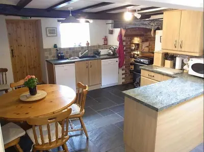 a kitchen with a wooden table and a table and chairs at Character cottage with spectacular views in Church Stoke