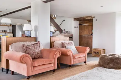 a living room with two chairs and a rug at River Cottage by Birch Stays in Glasbury