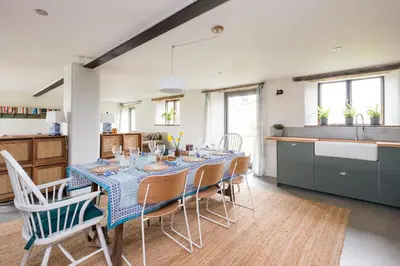 a kitchen and dining room with a table and chairs at River Cottage by Birch Stays in Glasbury