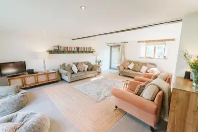 a living room with two couches and a tv at River Cottage by Birch Stays in Glasbury