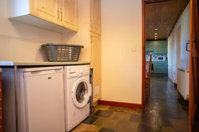 a kitchen with a washing machine in a room at Tan-yr-Onnen Llangrannog in New Quay