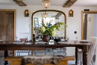 a dining room with a table and a mirror at Welsh Border Escape- Perfect for families & groups in Clyro