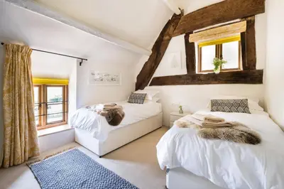 two beds in a room with two windows at Welsh Border Escape- Perfect for families & groups in Clyro