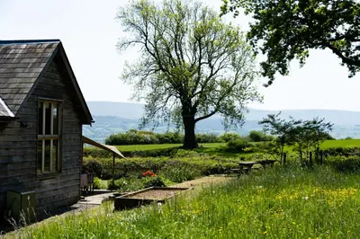 an old house with a garden and a tree at Welsh Border Escape- Perfect for families & groups in Clyro