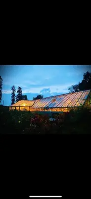 a large greenhouse in a field with the sky in the background at The carriage in Three Cocks Junction