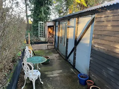 a patio with two chairs and a table and a building at The carriage in Three Cocks Junction