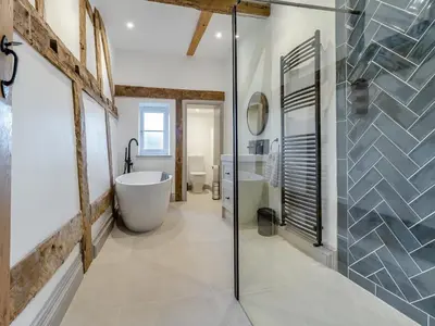 a bathroom with a tub and a glass shower at The Farmhouse - Uk48653 in Church Stretton