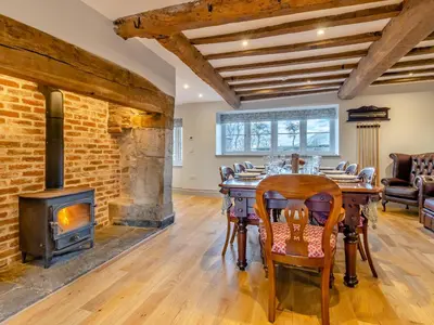 a dining room with a fireplace and a table and chairs at The Farmhouse - Uk48653 in Church Stretton