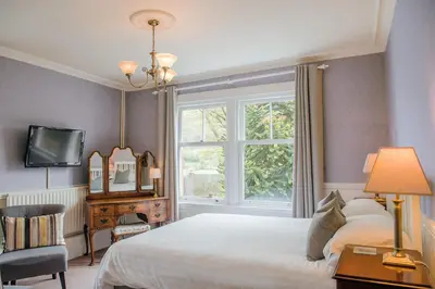 a bedroom with a white bed and a window at Mynd House in Church Stretton