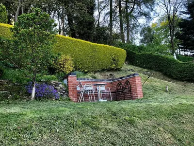 a brick wall with two chairs and a table at Mynd House in Church Stretton