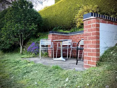 two chairs and a table in a brick wall at Mynd House in Church Stretton