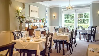 a dining room with tables and chairs in a restaurant at Mynd House in Church Stretton