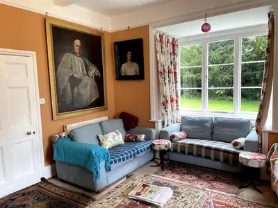 a living room with two blue couches and a painting at Lower Buckton Country Living Big House near Ludlow 6 bedrooms sleep 12 in Leintwardine