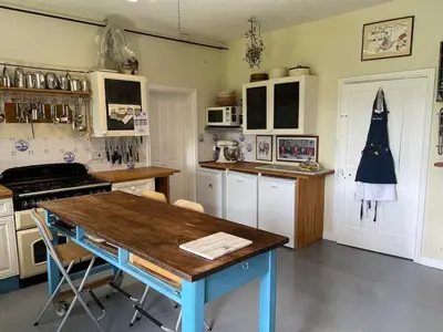 a kitchen with a wooden table and a blue table at Lower Buckton Country Living Big House near Ludlow 6 bedrooms sleep 12 in Leintwardine