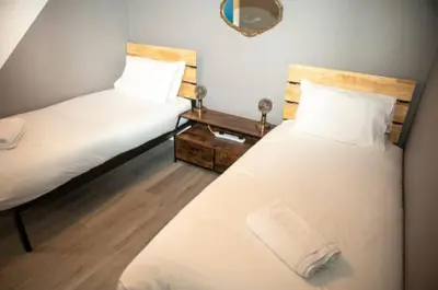 a bedroom with two beds and a table with a mirror at The House of Gnarrr in Machynlleth