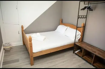 a bedroom with a swing bed with white sheets at The House of Gnarrr in Machynlleth