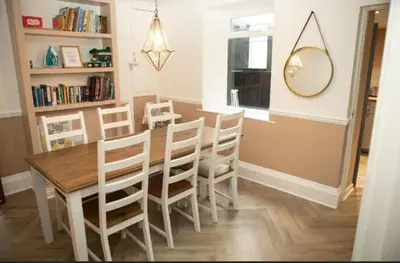 a dining room with a table and chairs and a mirror at The House of Gnarrr in Machynlleth