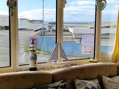 a toy lighthouse sitting on a couch in front of a window at Sea View Escape 2 Bedroom Pet Friendly Caravan at Clarach Bay Gm3 in Aberystwyth