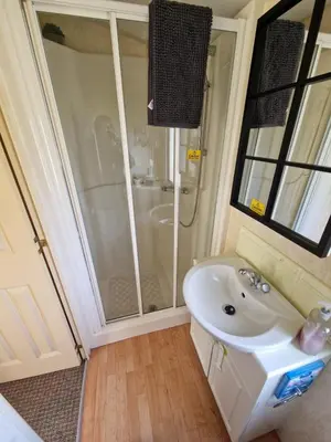 a bathroom with a shower and a white sink at Sea View Escape 2 Bedroom Pet Friendly Caravan at Clarach Bay Gm3 in Aberystwyth
