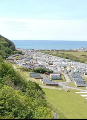 an aerial view of a parking lot near the ocean at Sea View Escape 2 Bedroom Pet Friendly Caravan at Clarach Bay Gm3 in Aberystwyth