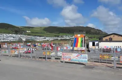 a parking lot with a bunch of signs on a fence at Sea View Escape 2 Bedroom Pet Friendly Caravan at Clarach Bay Gm3 in Aberystwyth