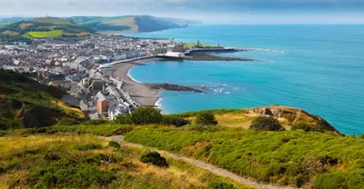 a town on a hill next to the ocean at Sea View Escape 2 Bedroom Pet Friendly Caravan at Clarach Bay Gm3 in Aberystwyth