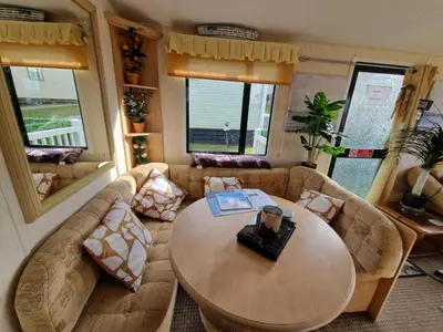 a living room with a couch and a table at Sea View Escape 2 Bedroom Pet Friendly Caravan at Clarach Bay Gm3 in Aberystwyth