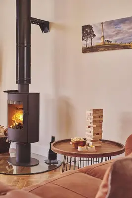 a fireplace in a living room with a table at Upper Tumble Cottage in Montgomery