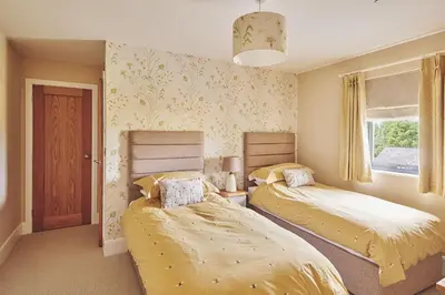 a bedroom with two beds and a window at Upper Tumble Cottage in Montgomery