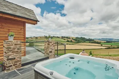 a jacuzzi tub on the patio of a house at Upper Tumble Cottage in Montgomery
