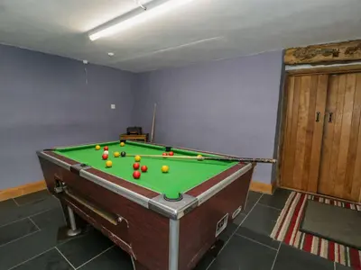 a pool table with balls on it in a room at Ysgubor in Machynlleth