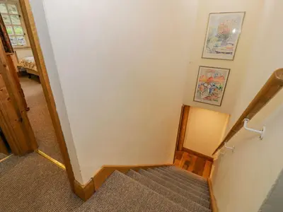 a staircase in a home with two pictures on the wall at Ysgubor in Machynlleth