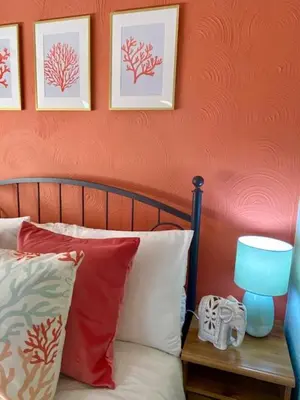 a bed with pillows and a blue lamp on a table at Cosy 3 bedroom cottage by the sea in Aberdovey in Aberdyfi