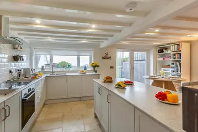 a large kitchen with white cabinets and a large window at 2 Bed in Llanfair oc-a30451 in Llanfair