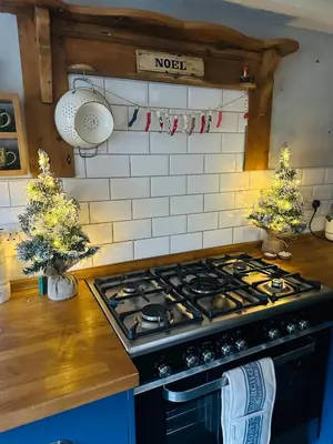 a kitchen with a stove top oven in a kitchen at Little Cottage, Llwyngwril in Llwyngwril