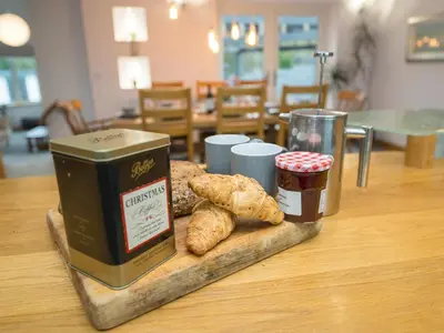 a table topped with bread and jam and a box of croissants at Modern 4-Bed Home Spacious & Comfortable - Pass the Keys in Pontesbury