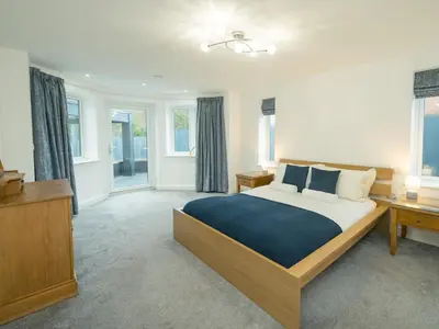 a bedroom with a large bed with a blue blanket at Modern 4-Bed Home Spacious & Comfortable - Pass the Keys in Pontesbury