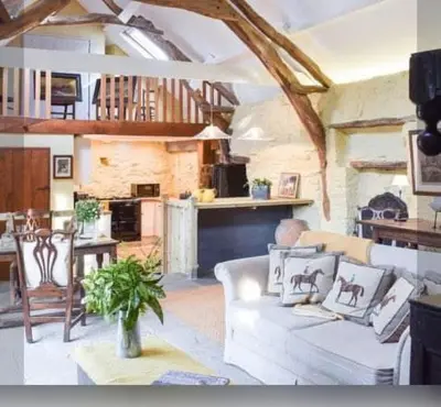 a living room with a white couch and a table at Glovers cottage private hot tub and super king in Llanrhystyd