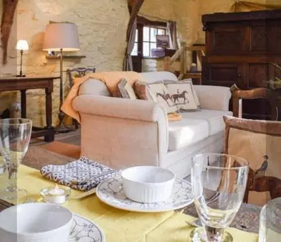 a living room with a couch and a table with glasses at Glovers cottage private hot tub and super king in Llanrhystyd