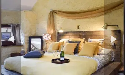 a bedroom with a large bed with a bottle of champagne at Glovers cottage private hot tub and super king in Llanrhystyd