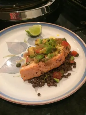 a plate with a piece of fish with beans and a lime at Bryn Teg Barn in Dyffryn